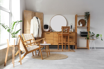 Interior of modern room with dressing table, stylish armchairs and houseplants
