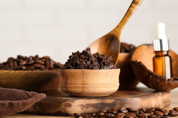 Composition with wooden tray and coffee body scrub in bowl on light background