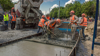 Concrete leveling works for road construction with many workers and mixer timelapse