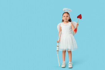 Cute little girl dressed as Cupid with arrow and bow on blue background. Valentine's Day celebration
