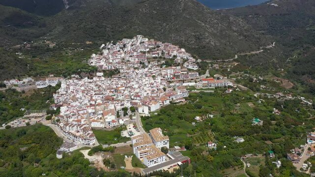 Panoramic aerial view of Ojen Village. Situated in South of Spain, Andalucia. Tipicaly Spanish village with white houses, on top of the hills. Famous travel destination. Drone going forward.
