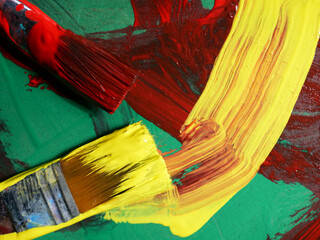 close-up yellow and red paintbrush and paint