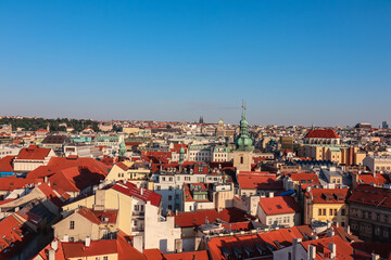 Obraz premium Breathtaking panoramic view of Prague, Czech Republic. City's iconic red-tiled roofs stretch out towards the horizon, creating vibrant and picturesque cityscape. historic architecture of the Old Town