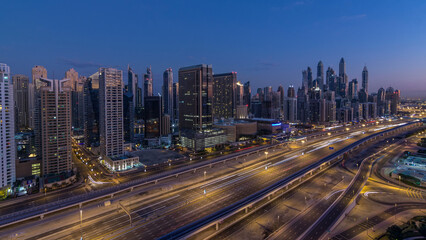 Dubai Marina skyscrapers aerial top view before sunrise from JLT in Dubai night to day timelapse, UAE.
