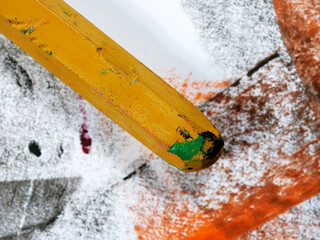 used and broken brown pastel crayons on painted paper background