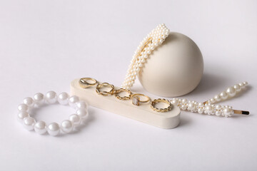 Decorative podiums with different beautiful jewelry on grey background