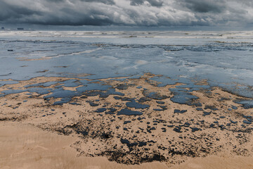 Oil in sea beach after a tanker wreck. Oil fuel polluted beach