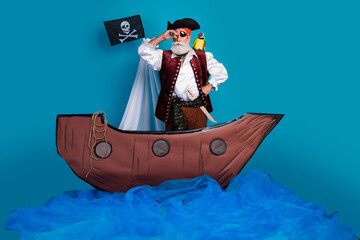 Full length photo of senior funny pirate grandpa use binoculars tube wear masquerade party costume...