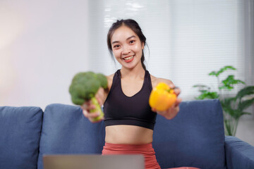 Young nutritionist engaging in a video call on a laptop, showcasing vibrant healthy foods like...