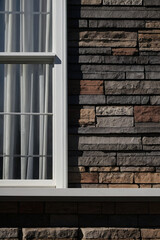 Obraz premium White-Framed Window and Stone Brick Wall