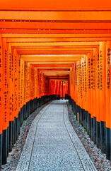 Fototapeta premium The torii gate covered walking path at Fushimi Inari Taisha temple in Kyoto, Japan. ( Japanese inscriptions translated are different religion blessings)