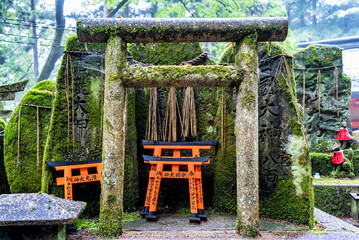 Small shinto place of worship with Torii Gates and inscriptioned stones at Fushimi Inari Taisha...