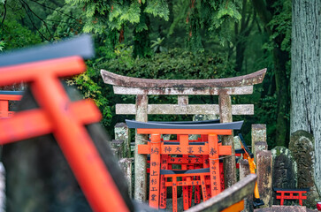 Small shinto place of worship with Torii Gates and inscriptioned stones at Fushimi Inari Taisha...