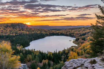 Fototapeta premium Scenic sunset view over a tranquil lake surrounded by colorful autumn foliage.