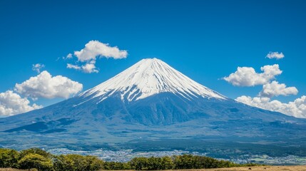 A scenic view of Mount Fuji under a clear blue sky with fluffy clouds.