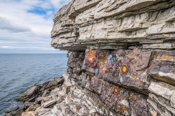 Colorful mineral deposits on rocky cliff by the sea