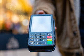 Salesperson holding pos terminal for contactless payment in store
