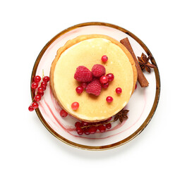 Plate of sweet pancakes with raspberries, red currants and cinnamon on white background