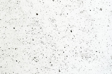 Naklejka premium White concrete texture with black speckles and irregular surface pattern