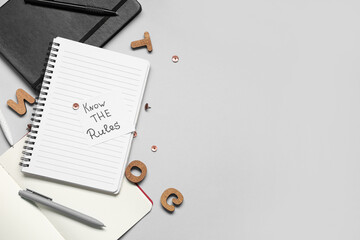 Paper with text KNOW THE RULES and notebooks on light background