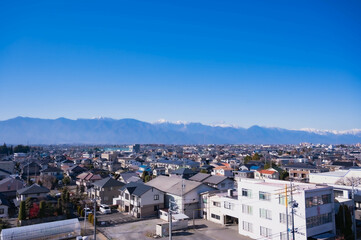 冬の北アルプスと町並み　