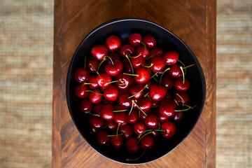 Cerezas frescas en un plato negro