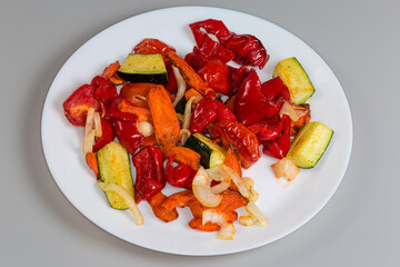 Different baked vegetables on dish on a gray background