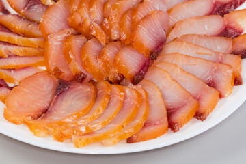 Sliced different cold smoked freshwater fish on plate, close-up