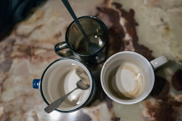 three empty mugs with spoons on table