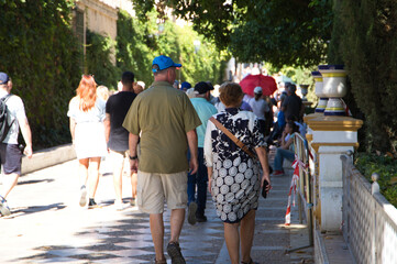 Group of tourists walking in Murillo gardens on a sunny day in Seville, andalusia, Spain. Travel...