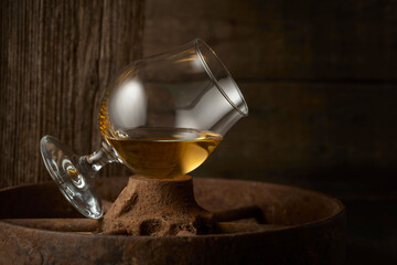 Cognac in snifter on old rusty wheel.
