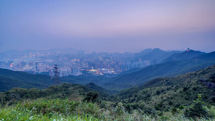 Cityscape of Hong Kong as viewed atop Kowloon Peak with day to night timelapse with Kowloon below