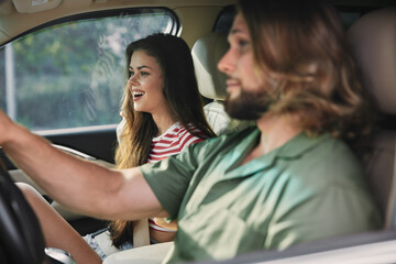 Joyful couple enjoying a drive in a car with natural light illuminating their smiles