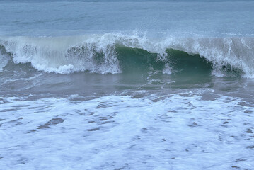 Detail of a wave breaking on the shore of the beach.