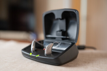 Hearing aid devices charging in a black case on a table