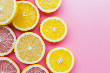 Fototapeta premium Bright citrus fruits arranged on pink surface