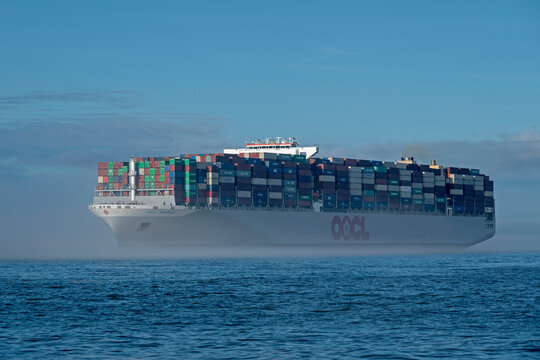 Suezmax class container ship OOCL Bangkok sails out of Charleston Harbor, SC, USA in low-lying fog on December 17, 2024.