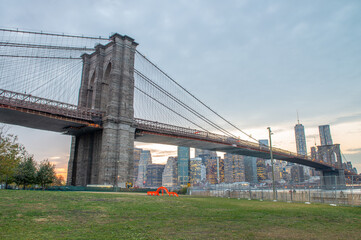 Fototapeta premium Sunset Over the Brooklyn Bridge, Capturing NYC’s Iconic Landmark in Golden Light