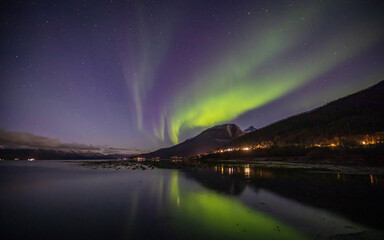 Spiegelung von Nordlichtern über dem Fjord bei Laksvatn an der E8 in der Nähe von Tromsø in Nordnorwegen