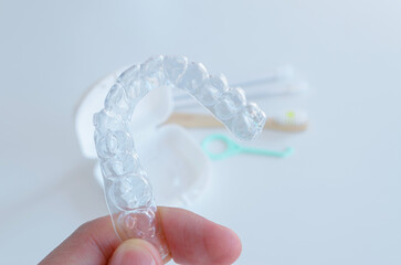 Alineador dental. Ortodoncia invisible. Placa alineadora invisalign, accesorios de higiene oral y fondo blanco. 