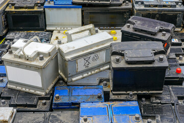 Stack of many used car batteries for recycling in a hazardous waste facility