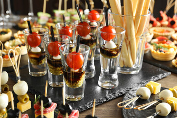 Many different tasty canapes on wooden table, closeup