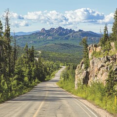 Scenic winding road through lush greenery with mountains in the background.