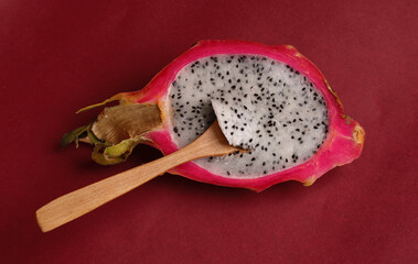 half of dragonfruit on burgundy background