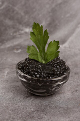 jar of black caviar on a light background