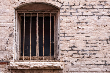 Old barred window and decaying brick work