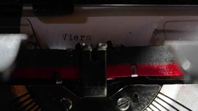 Las teclas de la antigua m&aacute;quina de escribir se visualizan en primer plano e imprimen en una hoja blanca palabras en idioma espa&ntilde;ol.	
