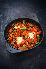 Greek style minced beef meat ragout stew with pumpkin, feta sheep cheese and capers in tomato sauce served es close-up in cast iron pan