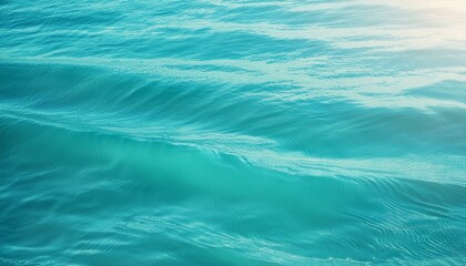 Obraz premium A serene light teal ocean background with gentle waves, soft gradients of teal, turquoise, and aqua, subtle sunlit reflections, and a calming, airy atmosphere perfect for relaxation.