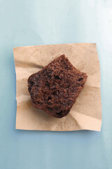 half of chocolate muffin on blue background